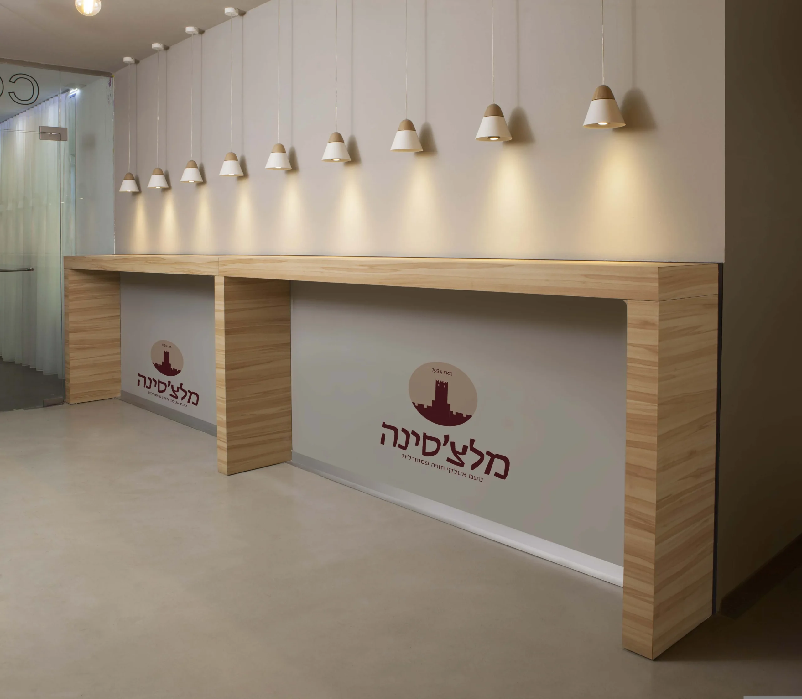 הלוגו של מלצ׳סינה על הדלפק בכניסה למסעדה